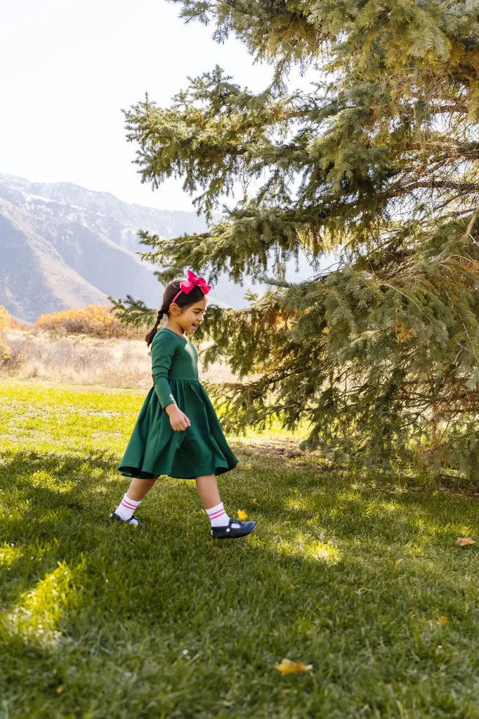 Little girl strolling around with her beautiful Gwendolyn Dress in Evergreen.
