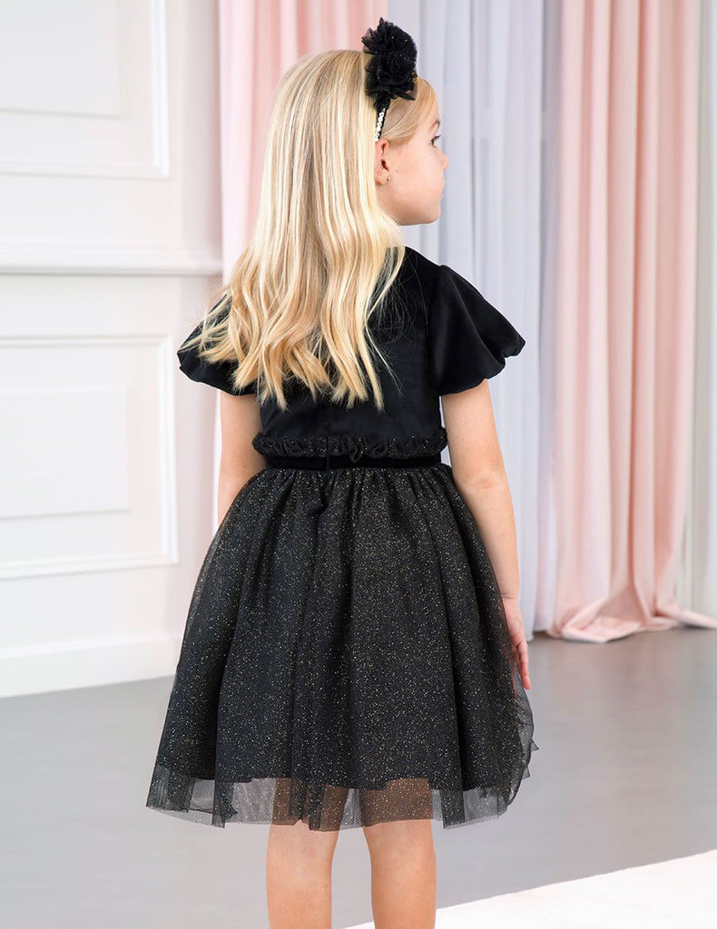Little Girl Wearing a Black Dress Facing Away From the Camera