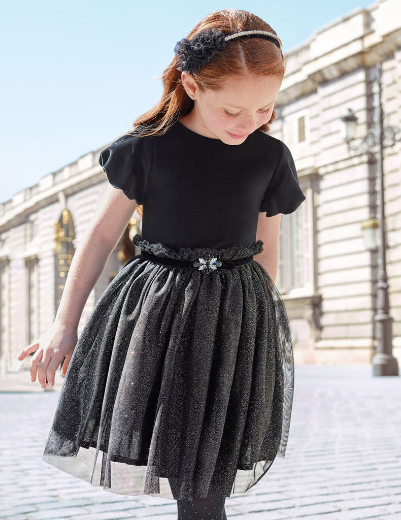 Little Girl Dress in Black Looking Down at the Ground Smiling