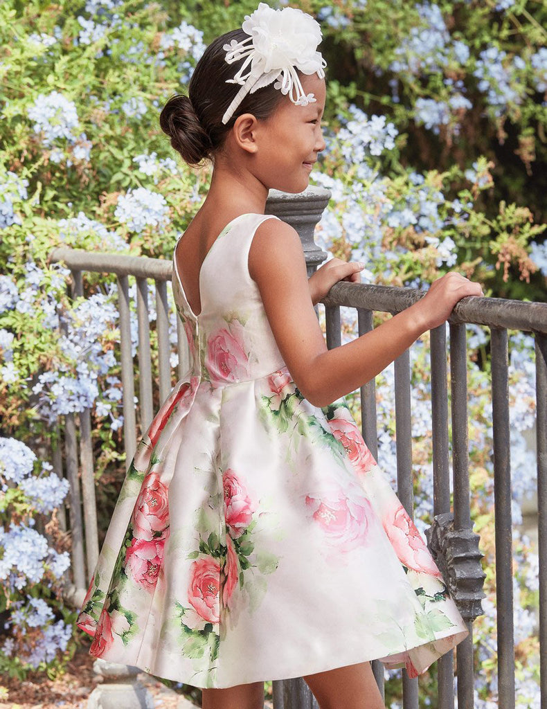 Girl Wearing Floral Dress Over Looking a Garden