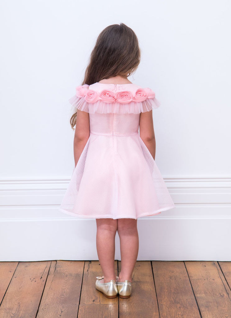 Little Girl Showing her back Wearing David Charles Sugar Pink Tiered Dress.