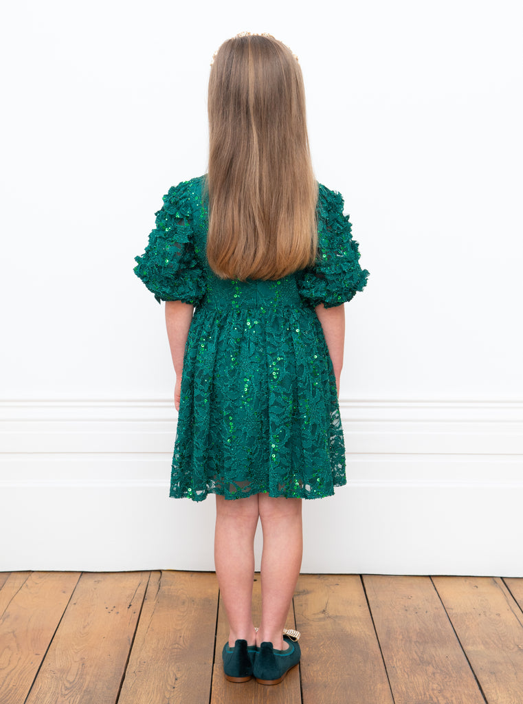 Little Girl posing her back wearing David Charles Green Lace Dress.