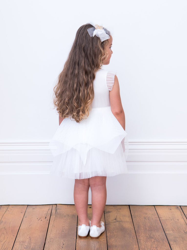 Little Girl looking back wearing David Charles Ivory Butterfly Bridesmaid Gown.