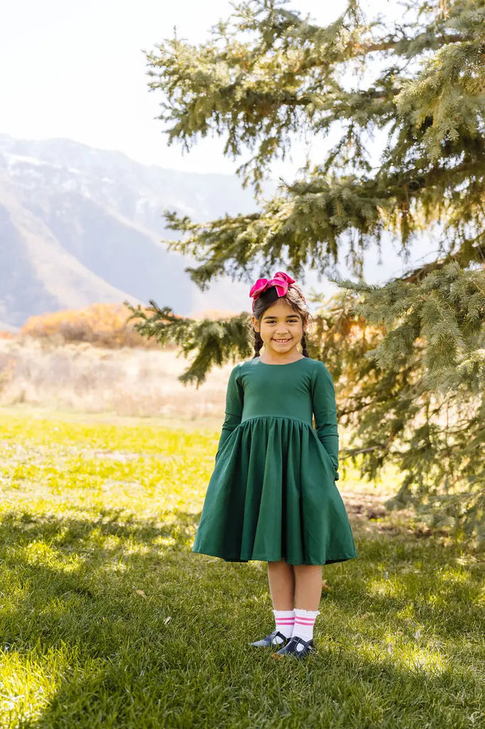 Little Girl posing in Wearing Gwendolyn Dress in Evergreen.