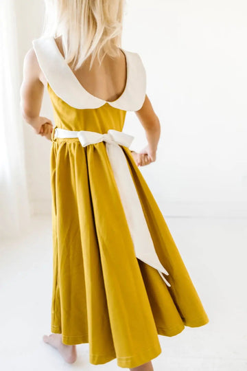 Little Girl showing the back of Mustard Grace Dress.